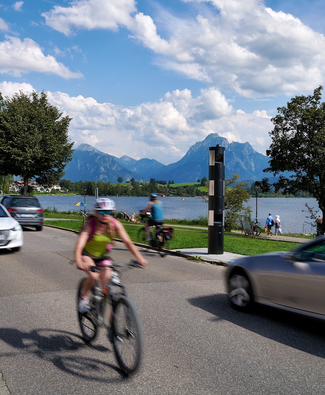 A road at the lake with car traffic, cyclists and pedestrians