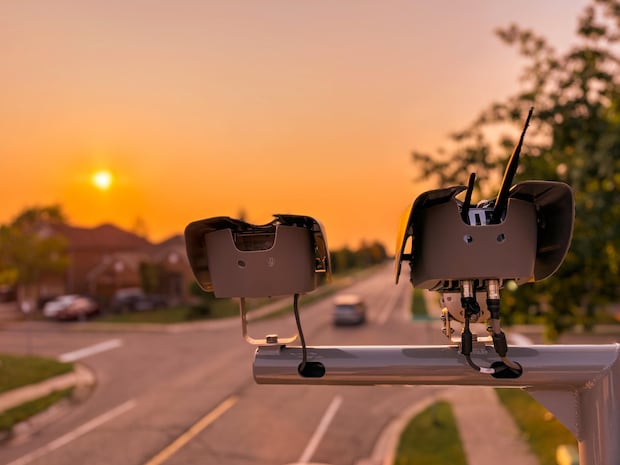 2 Kameras am Mast über einer Straße montiert mit Sonne im Hintergrund